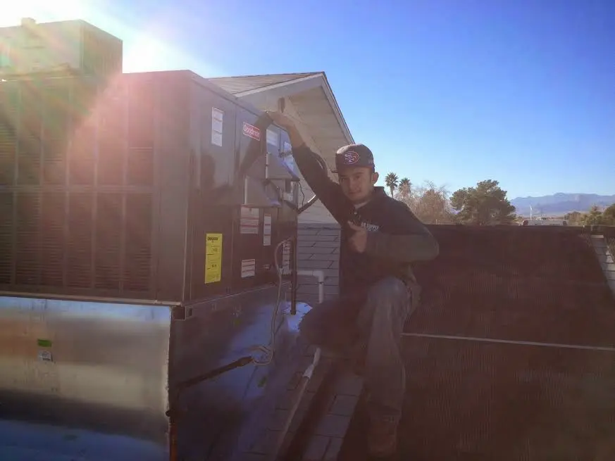 HVAC technician performing Air Duct Cleaning on a rooftop unit in Shrewsbury
